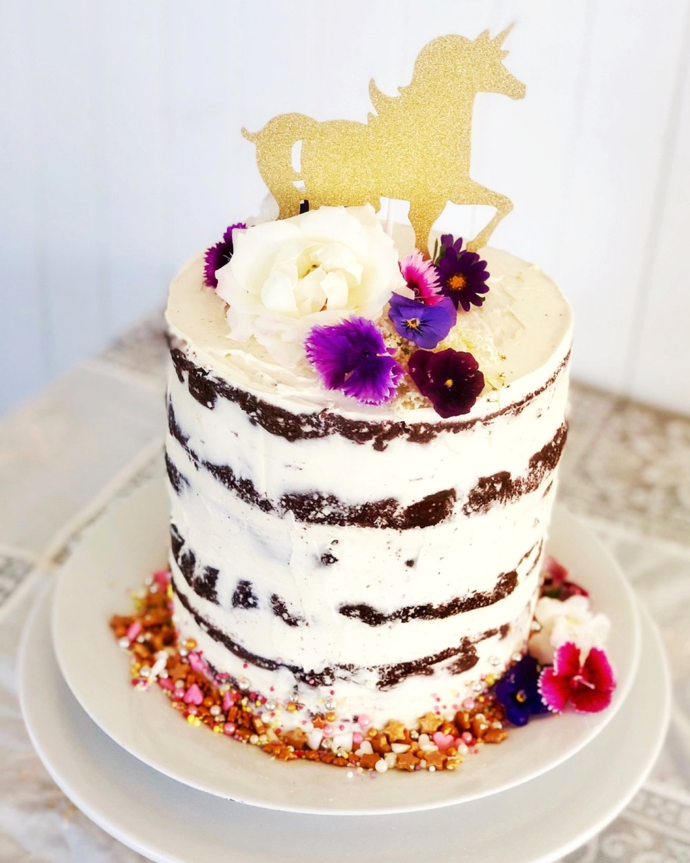 CELEBRATION CAKE$100 - Our chef can customise a beautiful semi-naked style celebration cake adorned with fresh flowers to provide a decadent finale to your child's party. Serves up to 30 people.