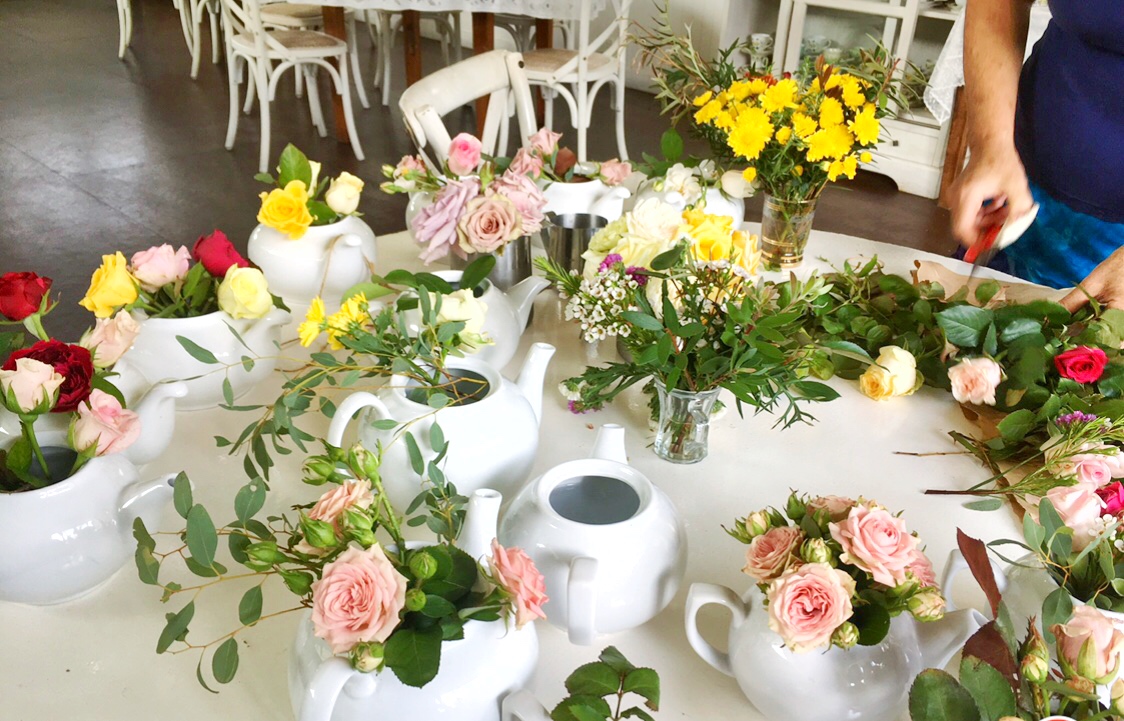 Fresh flowers in tea pots make a fragrant table centrepiece for your high tea setting.
